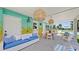 Covered patio with wicker furniture, a dining table, and string lights overlooks the inviting pool area at 156 Myakka Rd, Venice, FL 34293