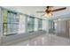 Sunroom features marble floors, a ceiling fan, and bright windows with light and airy curtains at 156 Myakka Rd, Venice, FL 34293