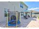 Back patio featuring trampoline, patio furniture, and umbrella, perfect for outdoor activities at 17330 Harvest Moon Way, Bradenton, FL 34211