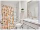 Well-lit bathroom featuring a tub and shower, vanity sink with marbled countertop, and a vibrant, patterned shower curtain at 17330 Harvest Moon Way, Bradenton, FL 34211