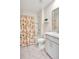 Bathroom featuring a tub and shower, vanity sink with marbled countertop, and a vibrant, patterned shower curtain at 17330 Harvest Moon Way, Bradenton, FL 34211