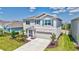 Two-story home featuring a well-maintained lawn, landscaped garden, and attached two-car garage at 17330 Harvest Moon Way, Bradenton, FL 34211