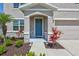 Welcoming front entrance with a blue door, beautiful landscaping, and stone accents at 17330 Harvest Moon Way, Bradenton, FL 34211