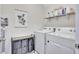 Functional laundry room with washer, dryer, open shelving, and a convenient rolling cart for organization at 17330 Harvest Moon Way, Bradenton, FL 34211