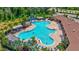 Aerial view of uniquely shaped community pool featuring ample seating and lush landscaping at 17330 Harvest Moon Way, Bradenton, FL 34211