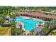 Aerial view of community pool featuring spacious deck, covered seating, and lush landscaping at 17330 Harvest Moon Way, Bradenton, FL 34211