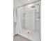 Modern walk-in shower with rainfall showerhead and built-in shelves, complemented by white walls and bright lighting at 17330 Harvest Moon Way, Bradenton, FL 34211