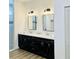 Bathroom featuring a double sink vanity, ample storage, and sleek fixtures, and walk-in shower at 17605 Roanwood Ct, Parrish, FL 34219