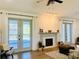 Cozy living room with fireplace, ceiling fan, and access to the outdoor living space at 17605 Roanwood Ct, Parrish, FL 34219
