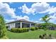 This is a charming back exterior with a manicured lawn and gorgeous plantings and a screened-in patio at 17725 Northwood Pl., Bradenton, FL 34202
