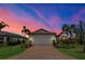 Beautiful home exterior with a brick-paved driveway, well-manicured lawn, and professional landscaping at dusk at 17725 Northwood Pl., Bradenton, FL 34202