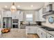 Bright kitchen featuring granite counters, stainless appliances, white cabinets and a center island at 17725 Northwood Pl., Bradenton, FL 34202