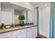 Bathroom featuring double sinks, a large mirror, and a walk-in shower with sleek fixtures at 18303 Wheathouse Pl, Lakewood Ranch, FL 34211