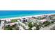 Aerial view capturing beachfront condominiums with a pool, parking area, and beach access at 1945 Gulf Of Mexico Dr # M2-313, Longboat Key, FL 34228