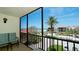 Relaxing balcony with seating offers serene views of lush landscaping and the nearby beach at 1945 Gulf Of Mexico Dr # M2-313, Longboat Key, FL 34228