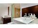 Bathroom featuring a vessel sink, wood cabinet, and glass enclosed shower with neutral toned tile at 1945 Gulf Of Mexico Dr # M2-313, Longboat Key, FL 34228