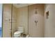 Modern bathroom with toilet and glass-enclosed shower featuring neutral tile and contemporary fixtures at 1945 Gulf Of Mexico Dr # M2-313, Longboat Key, FL 34228