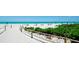 Scenic beach view with clear turquoise water, white sand, beach umbrellas and tropical greenery at 1945 Gulf Of Mexico Dr # M2-313, Longboat Key, FL 34228