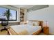 Bright bedroom with large window, built-in shelving, a desk, and a comfortable bed at 1945 Gulf Of Mexico Dr # M2-313, Longboat Key, FL 34228