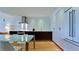 Modern kitchen and dining area with hardwood floors, stainless appliances, and glass dining table at 1945 Gulf Of Mexico Dr # M2-313, Longboat Key, FL 34228
