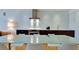 Kitchen and dining area with modern cabinetry, stainless steel appliances, and modern dining table at 1945 Gulf Of Mexico Dr # M2-313, Longboat Key, FL 34228
