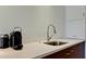 Close-up of the kitchen with a stainless steel sink, modern faucet, and a countertop coffee maker at 1945 Gulf Of Mexico Dr # M2-313, Longboat Key, FL 34228