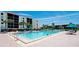 Sunny condo complex pool with lounge chairs, umbrellas and palm trees, ideal for relaxing and enjoying the outdoors at 1945 Gulf Of Mexico Dr # M2-313, Longboat Key, FL 34228