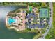 Aerial view of community amenities, including pool, tennis courts, playground, and ample parking, nestled by a picturesque lake at 197 Villoresi Blvd, Nokomis, FL 34275