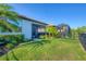 Large backyard featuring lush green grass, fencing, mature landscaping, and screen enclosed lanai at 197 Villoresi Blvd, Nokomis, FL 34275