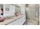 Bathroom with a double vanity with granite counters, a large mirror, and walk-in shower at 197 Villoresi Blvd, Nokomis, FL 34275