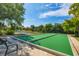 Outdoor bocce ball court surrounded by green landscaping, trees, and a bench with views of the pond at 197 Villoresi Blvd, Nokomis, FL 34275
