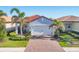 Charming single-story home with a red tile roof, lush landscaping, and a brick driveway at 197 Villoresi Blvd, Nokomis, FL 34275