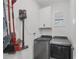Modern laundry room with front loading washer and dryer, built-in cabinets and window at 197 Villoresi Blvd, Nokomis, FL 34275