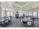 Spacious resident lounge with a fireplace, large windows, leather seating, tables, and a chandelier at 197 Villoresi Blvd, Nokomis, FL 34275