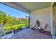 Screened lanai with brick floor, fan and seating overlooks the lush backyard at 197 Villoresi Blvd, Nokomis, FL 34275
