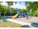Community playground featuring a slide, climbing structures, and a bench surrounded by trees and landscaping at 197 Villoresi Blvd, Nokomis, FL 34275