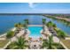 Aerial view of the resort style community pool overlooking the lake with plenty of lounge chairs and palm trees at 197 Villoresi Blvd, Nokomis, FL 34275