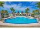 Enjoy the community's resort-style pool with ample seating, lush landscaping, and a beautiful clubhouse in the background at 197 Villoresi Blvd, Nokomis, FL 34275