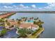 Aerial view of the community pool surrounded by lounge chairs, palm trees, and landscaping overlooking the lake at 197 Villoresi Blvd, Nokomis, FL 34275