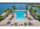 Aerial view of a large, resort-style pool surrounded by palm trees and lounge chairs, perfect for relaxation and recreation at 197 Villoresi Blvd, Nokomis, FL 34275