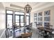 Resident seating area with tables, chairs, and natural lighting from large windows and a modern orb chandelier at 197 Villoresi Blvd, Nokomis, FL 34275