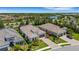 An aerial view showcases homes with beautiful landscaping in a serene neighborhood near a lake at 204 Corelli Dr, Nokomis, FL 34275