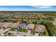 Expansive aerial view of the community showcasing well-maintained homes, lush greenery, and a serene lake at 204 Corelli Dr, Nokomis, FL 34275
