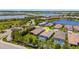 Aerial view of a home with a screened-in pool in a residential community near a lake at 204 Corelli Dr, Nokomis, FL 34275