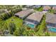 Aerial view of a screened-in pool with lush landscaping in the backyard of a residential property at 204 Corelli Dr, Nokomis, FL 34275
