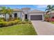 Charming home with lush landscaping, a two-car garage, and a beautifully paved driveway at 204 Corelli Dr, Nokomis, FL 34275
