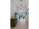 Inviting hallway featuring light wood floors, elegant lighting, and a decorative cabinet at 204 Corelli Dr, Nokomis, FL 34275