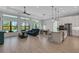 Open-concept living space featuring a kitchen, dining area, and living room with tiled floors and large windows at 204 Corelli Dr, Nokomis, FL 34275