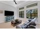 Cozy living room with a plush couch, large windows, and a stylish blue cabinet at 204 Corelli Dr, Nokomis, FL 34275
