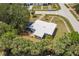 Aerial view of home with mature trees, landscaping, and a metal roof at 22275 Belinda Ave, Port Charlotte, FL 33952